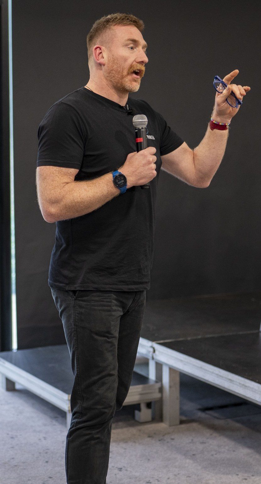 Rob Murray speaking to an audience, microphone in hand